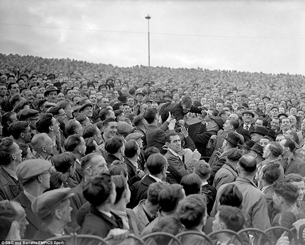 Мястото на това момче е най-отпред! Феновете си препредават малчугана, за да му осигурят позиция пред трибуната, по време на мача Челси - Арсенал (1947 г.)