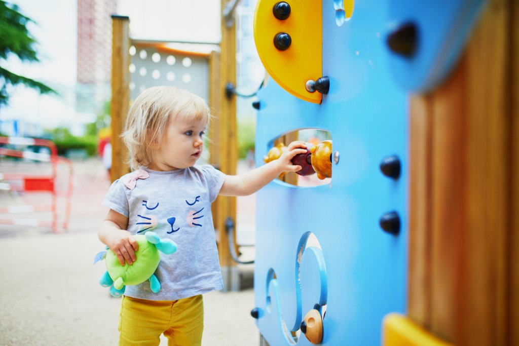 Adorable toddler girl having fun on playground