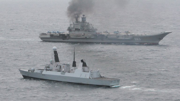 Британският HMS Dragon ескортира "Адмирал Кузнецов" през Ла Манша. Руският кораб стана известен със своя пушещ комин 