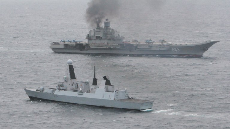 Британският HMS Dragon ескортира "Адмирал Кузнецов" през Ла Манша. Руският кораб стана известен със своя пушещ комин