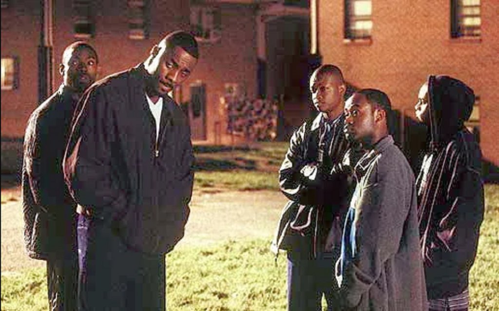 2. The Wire / „Наркомрежа“ (2002–2008)
Започва като разследване на наркотрафика в Балтимор, но постепенно разширява погледа си към целия град. Полицията, пристанището, местната власт, училищата и пресата се оказват части от една система, в която чуждите решения ограничават личния избор.
Създаден от бившия журналист Дейвид Саймън с ключовото участие на бившия полицай и учител Ед Бърнс, „Наркомрежа“ черпи от прякото им познаване на тази среда.
Всеки от петте сезона добавя нов пласт към картината. Сериалът изисква внимание към множество герои и връзки, а вместо лесни победи предлага трудни въпроси: кой определя правилата, кого обслужват те и какво става с хората, които се опитват да ги променят.