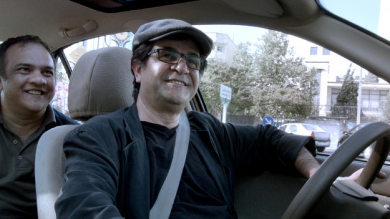 Такси

Трагикомичен портрет на иранското общество през преживяванията на шофьор на такси по улиците на Техеран. В главната роля е самият режисьор Джафар Панахи, а пътниците му са колоритни иранци, които казват много за страната, чиято душа той се стреми да улови.

След „Това не е филм“ и „Спуснати завеси“, „Такси“ е третият пълнометражен филм, заснет от Панахи въпреки забраната от властите да прави кино - след ареста му през 2010 г., когато се подготвяше да снима за протестите срещу преизбирането на президента Махмуд Ахмадинеджад. Осъден на шест години затвор и 20 години забрана да снима филми и да пътува, той беше освободен предсрочно, което му позволява да работи тайно, но без да може да напуска Иран. С „Такси” Панахи спечели „Златна мечка” на Берлинале.
