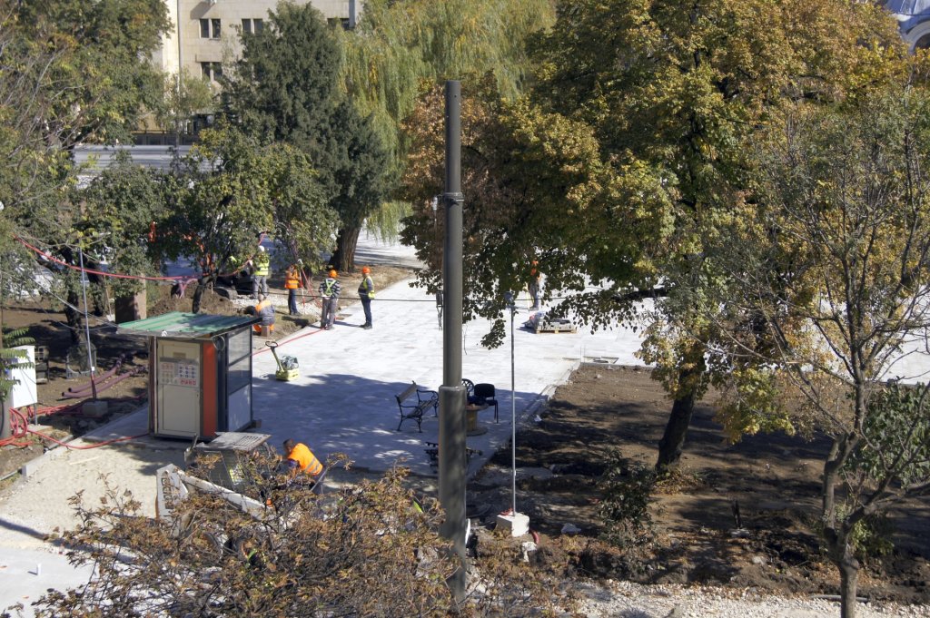 Вляво от църквата.