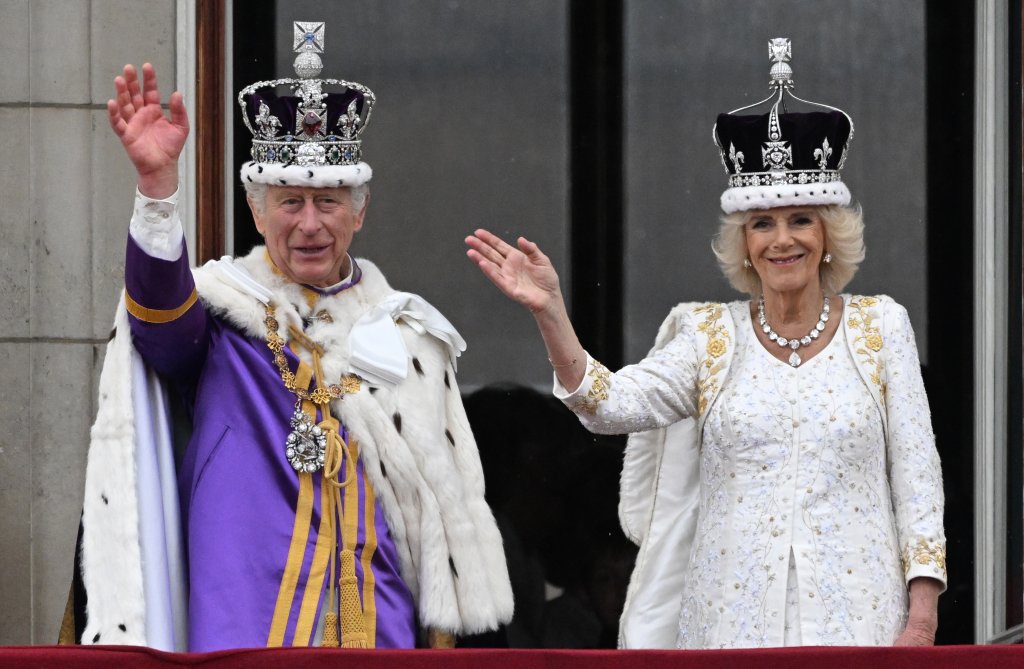 Британският крал Чарлз III (вляво) и кралица Камила махат от балкона на Бъкингамския дворец след коронацията си в Лондон. 
Дата: 06 май 2023 г.