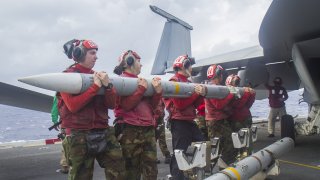 Китайски говорител предупреждава за ответни мерки (на снимката: американски войници заредят ракета въздух-въздух на изтребител F/A-18E)