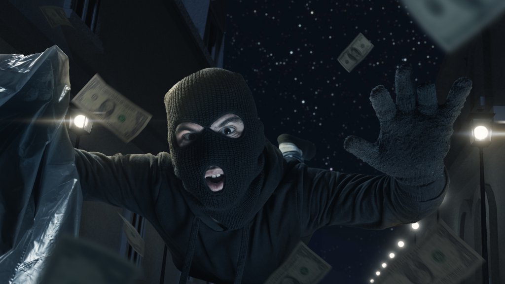 thief with balaclava and moneybag slipping and falling on the street