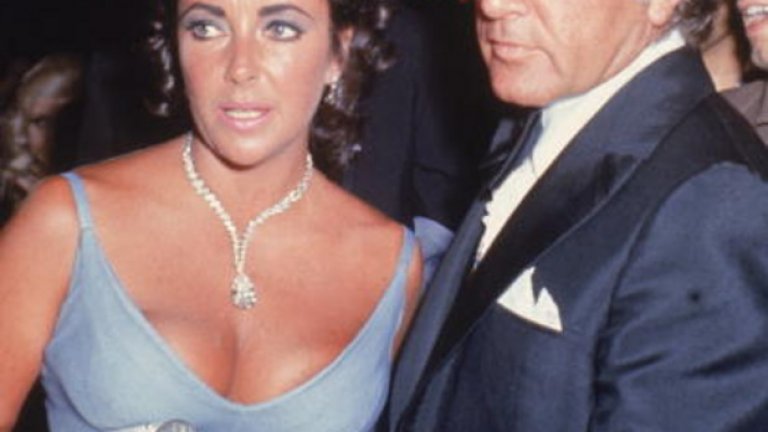 Бурната динамика между двойката кинозвезди Елизабет Тейлър и Ричард Бъртън се развива на червения килим на "Оскарите" през 1970, когато дълбоко изрязаната елегантна и разкриваща доста плът виолетова рокля и диамантената огърлица на Тейлър засенчват номинацията на съпруга й за "Оскар".