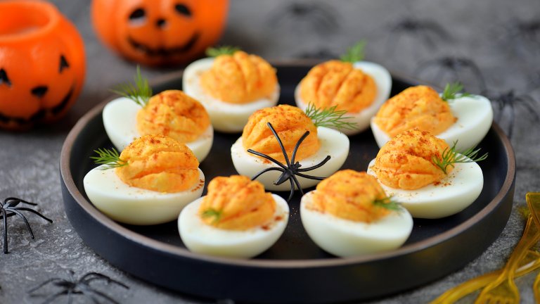 Дяволски яйцаТе са дяволски вкусни с леко пикантния си вкус и освен това са и дяволски лесни. За това апетитно предястие ни трябват 10-12 твърдо сварени яйца, 3-4 супени лъжици майонеза, 1-2 супени лъжици дижонска горчица, една люта чушка на много ситно, сол и пипер, няколко кисели краставички. По желание прибавяме и лют пипер или чили. 
Яйцата се разполовяват. Жълтъците се отделят в дълбока купа и се намачкват с майонезата, горчицата, лютата чушка и подправките. С помощта на супена лъжица или пош пълним разполовените белтъци и декорираме с половинка кисела краставичка, за да приличат дяволските яйца на тикви.
