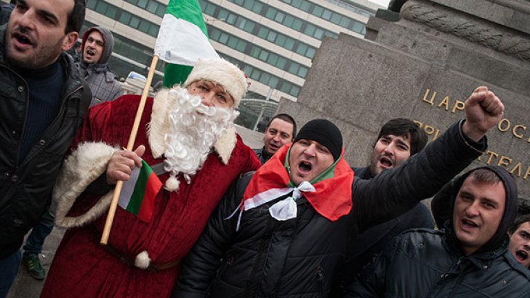 Протестиращ, облечен като Дядо Коледа, заедно с младежи, част от които бяха редовни участници в контрапротеста през лятото на миналата година