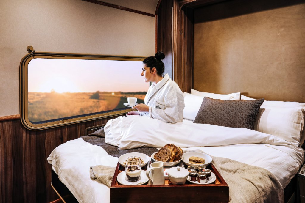 The GhanАвстралийската природа е пленителна и неповторима и The Ghan дава възможност на пасажерите си да ѝ се насладят в пълната ѝ красота. Маршрутът е от Дарвин до Аделаида и преминава през пустинни местности, солни полета и пясъчни образувания.
Влакът предлага както по-бюджетни купета, така и „Платинена услуга“, при която пътникът се настанява в просторна спалня със собствена баня. Оттам нататък купето се снабдява ежедневно с охладено шампанско, плодове и местни деликатеси.
Едно от най-забележителните неща обаче си остават панорамните прозорци, както и спирките из разнообразни местности за обяд на открито и вечеря край лагерен огън.