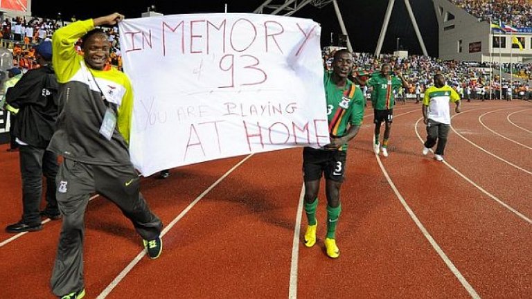 Футболистите на Замбия празнуват титлата, държейки плакат, посветен на загиналите през 1993 техни предшественици