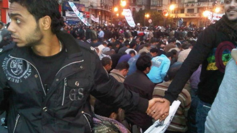 Египетски християни пазят мюсюлманите по време на молитвата им. Египет.