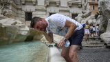 Предстои Световната метеорологична организация да потвърди измерванията, а същевременно температурите и в други части на Италия продължават да растат (на снимката: мъж се освежава във фонтан с Рим заради температурите от 39 градуса)