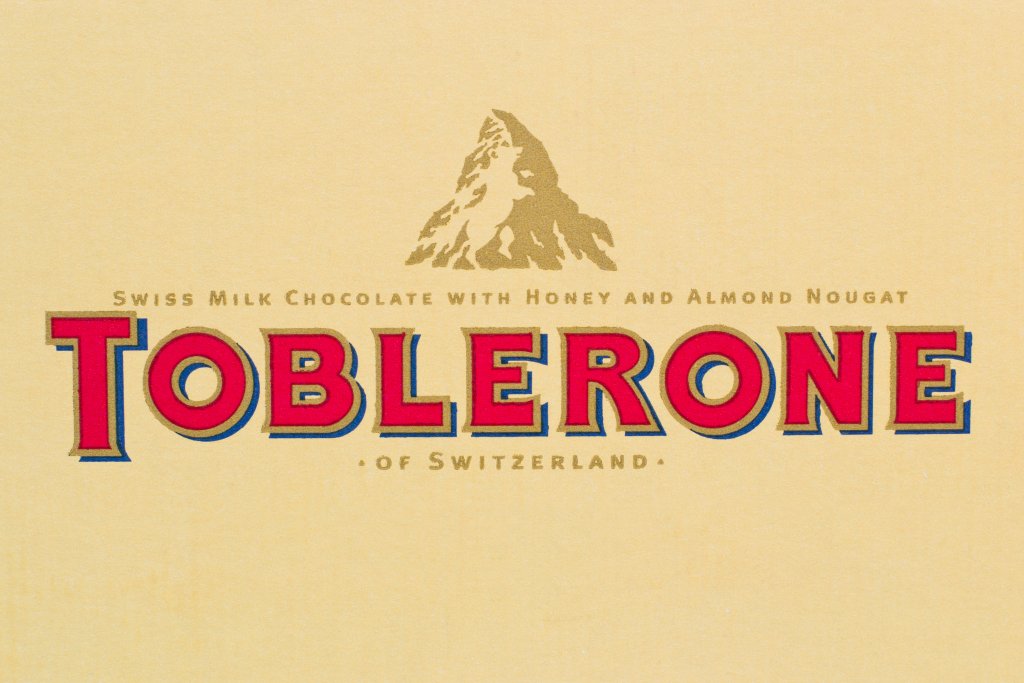 TobleroneДа, разбира се, на логото на Toblerone се вижда швейцарска планина, но при внимателно вглеждане се вижда и очертаният силует на изправена на два крака мечка. Мечката е символът на швейцарската столица Берн, където се ражда легендарният шоколад.