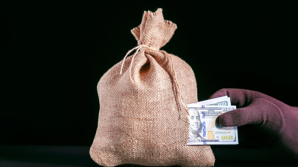Stealing Money. Money loss, tear in bag, money sack with hole and hand grabbing a pile of dollar banknotes