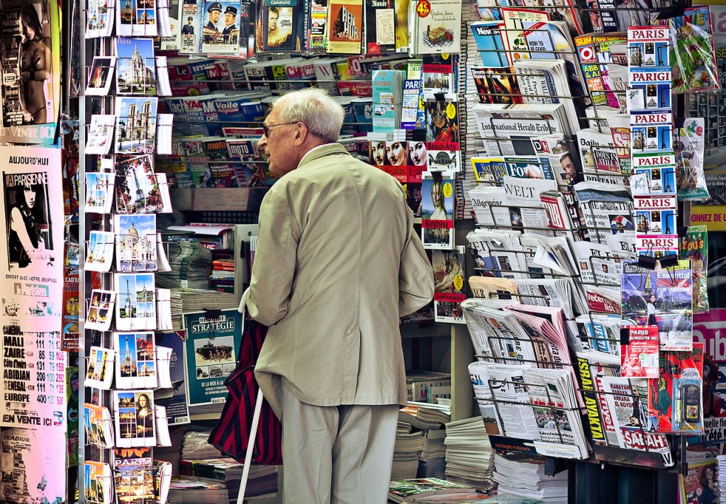 An_old_man_in_newsagent's_shop,_Paris_September_2011