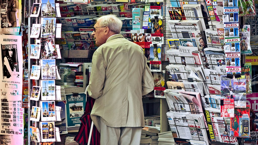 An_old_man_in_newsagent's_shop,_Paris_September_2011