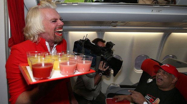 Собственикът на Virgin Atlantic Ричард Брансън, дегизиран като стюардеса, обслужва пътниците в AirAsia, след като се хваща на бас с Тони Фернандес, че неговият отбор във Формула 1 ще победи отбора на малайзиеца. 
