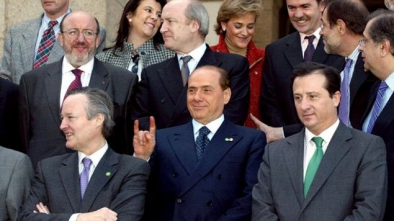 По време на среща на външните министри през 2002 г.,Берлускони се забавлява на официалните снимки
