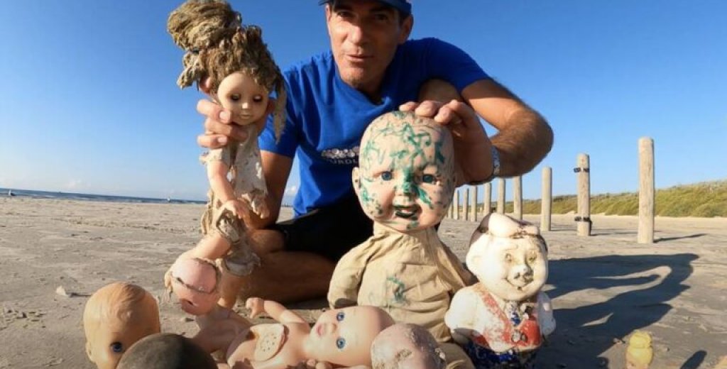 man-holding-up-creepy-dolls-in-texas-768x520