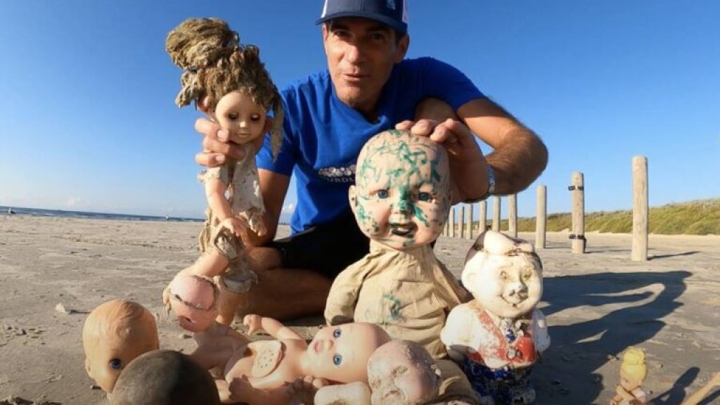 man-holding-up-creepy-dolls-in-texas-768x520