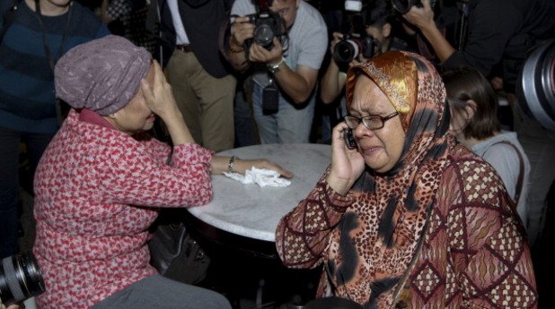 Близки на загиналите на полет MH17 на летището в Куала Лумпур, заобиколени от медиите