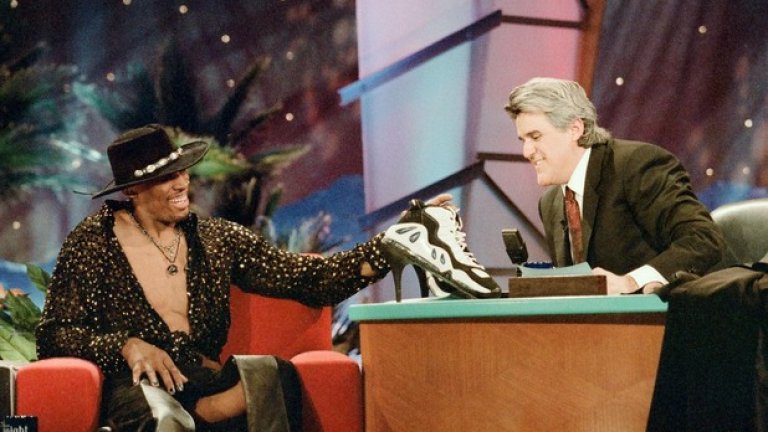 Джей Лено представя маратонките с токчета. Родман ги подписва и ги подарява на жена на първия ред.