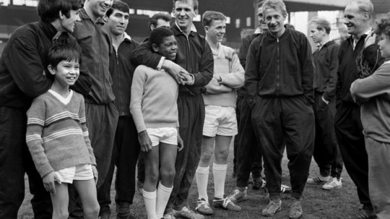 13 април 1965 г. - На среща с хлапета.
Все още сам ненавършил 19 години, той е сред звездите на Юнайтед, които се срещат с ученици от местно училище. Бест е вляво, до него е Дейвид Херд - голмайстор на Юнайтед този сезон, а в средата - звездите тогава Пади Креранд и Денис Лоус.
На тази снимка всички са усмихнати, но времето не е лесно за клуба - три дни по-рано отборът е отпаднал от Купата на ФА и то срещу врага Лийдс.