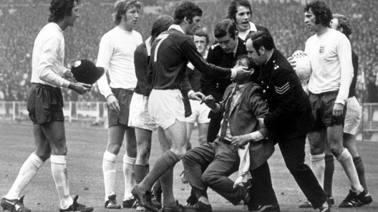 1973 г.: Уили Морган от Шотландия опитва да спаси от гневните лондонски полицаи запалянко, нахлул на терена. Английски играч носи шапката на едно от бобитата, паднала при залавянето на този фен.
