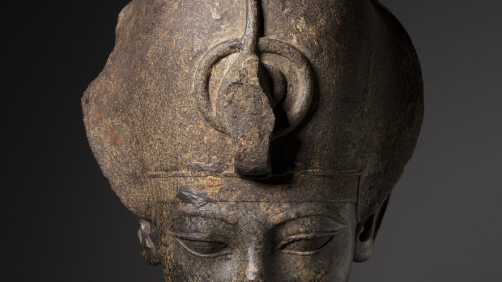 lossy-page1-906px-Egypt,_New_Kingdom,_Dynasty_18,_reign_of_Amenhotep_III_-_Head_of_Amenhotep_III_Wearing_the_Blue_Crown_-_1952.513_-_Cleveland_Museum_of_Art.tif