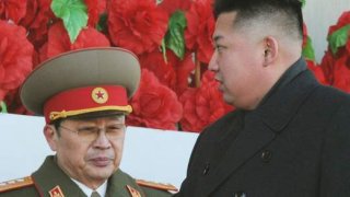 North Korean leader Kim Jong-un, flanked by his uncle North Korean politician Jang Song-thaek, leaves a military parade in Pyongyang